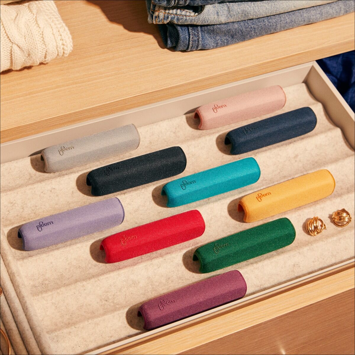 Urządzenie Ploom z etui Ploom AURA Back Cover Mango Sorbet stojące na stole
